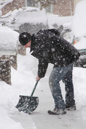 A man shoveling a sidewalk
